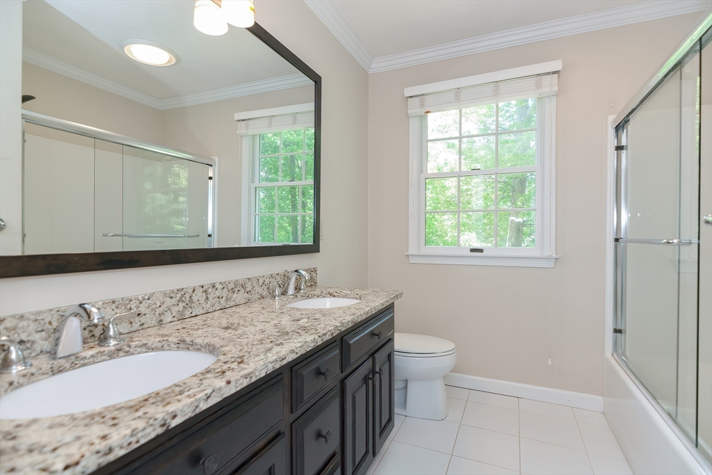 23 Newell Drive Franklin, MA 02038 - Photo 28 of 35 a bathroom with a granite countertop double vanity sink a mirror and a toilet