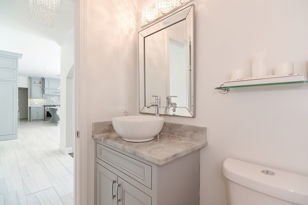 23 Newell Drive Franklin, MA 02038 - Photo 29 of 35 a bathroom with a granite countertop sink and a mirror