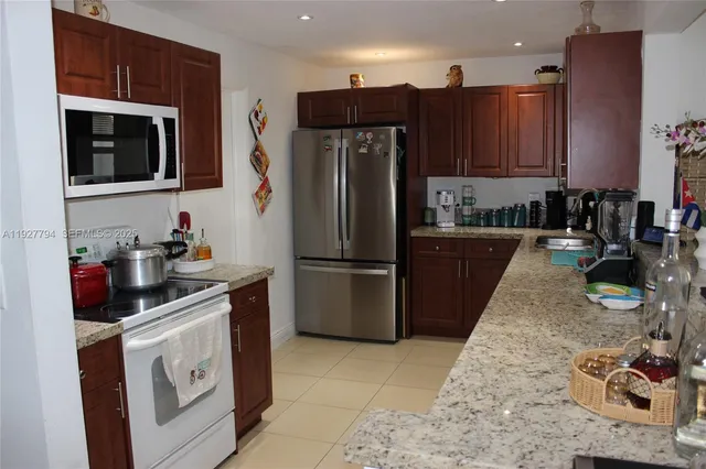 a kitchen with stainless steel appliances granite countertop a sink and a stove