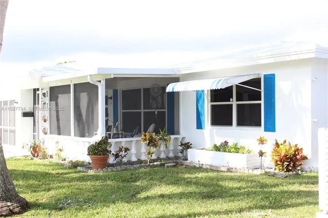 a front view of a house with a garden and yard