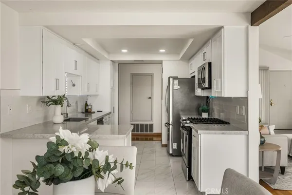 a living room with stainless steel appliances furniture a rug and a view