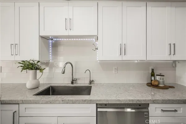 a kitchen with white cabinets and a potted plant