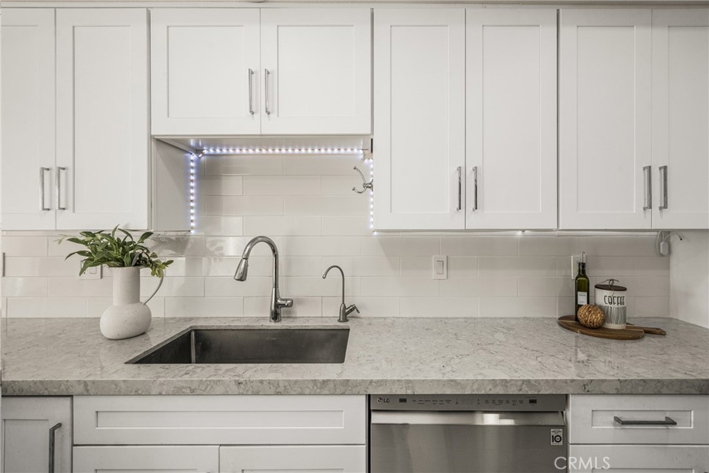 6 Whitecloud Irvine, CA 92614 - Photo 16 of 45 a kitchen with white cabinets and a potted plant