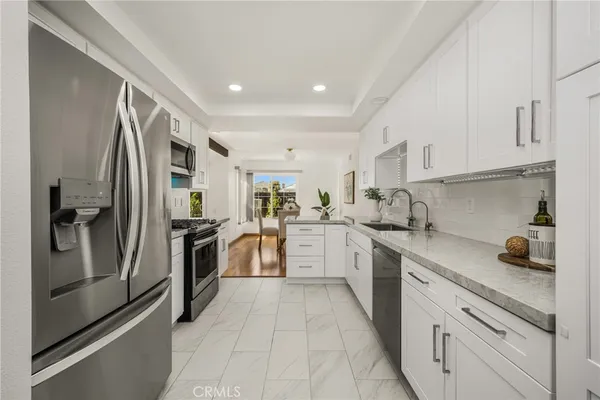 a kitchen with white cabinets and stainless steel appliances