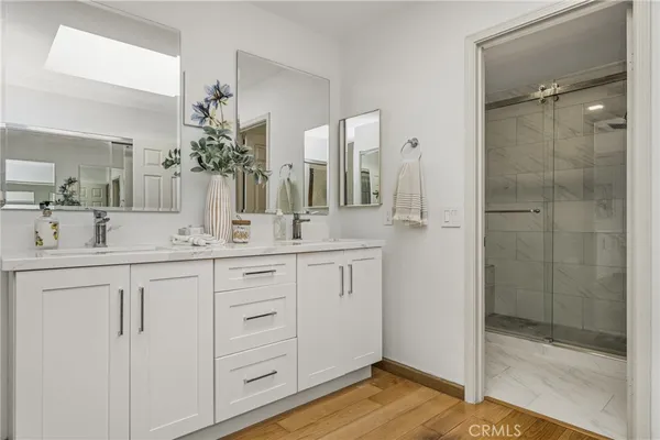 a bathroom with a double vanity sink mirror and shower