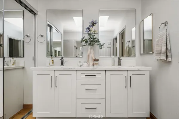 a bathroom with double vanity and a mirror