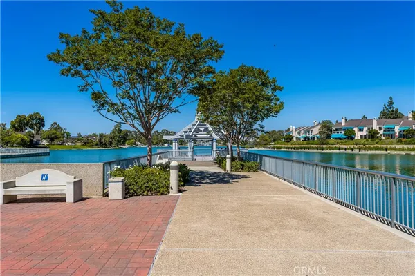 a view of a lake with couches and wooden fence