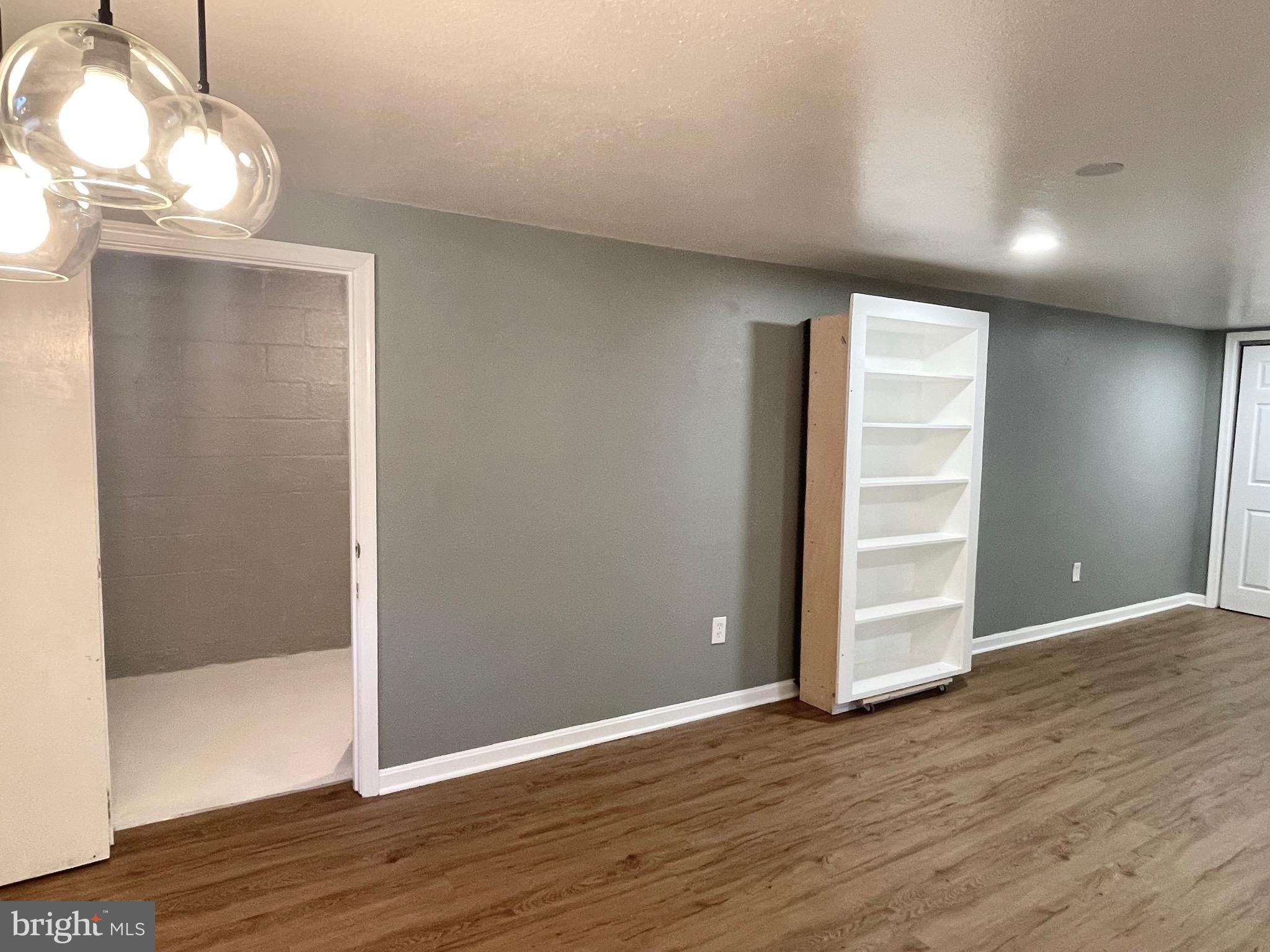 28321 Kemptown Road Damascus, MD 20872 - Photo 23 of 57 an empty room with wooden floor cabinet and windows