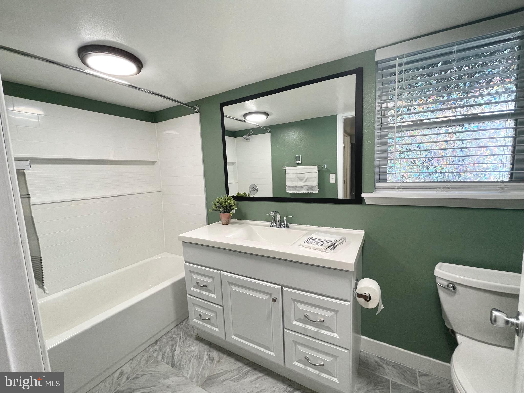 28321 Kemptown Road Damascus, MD 20872 - Photo 28 of 57 a bathroom with a sink a toilet a mirror and shower