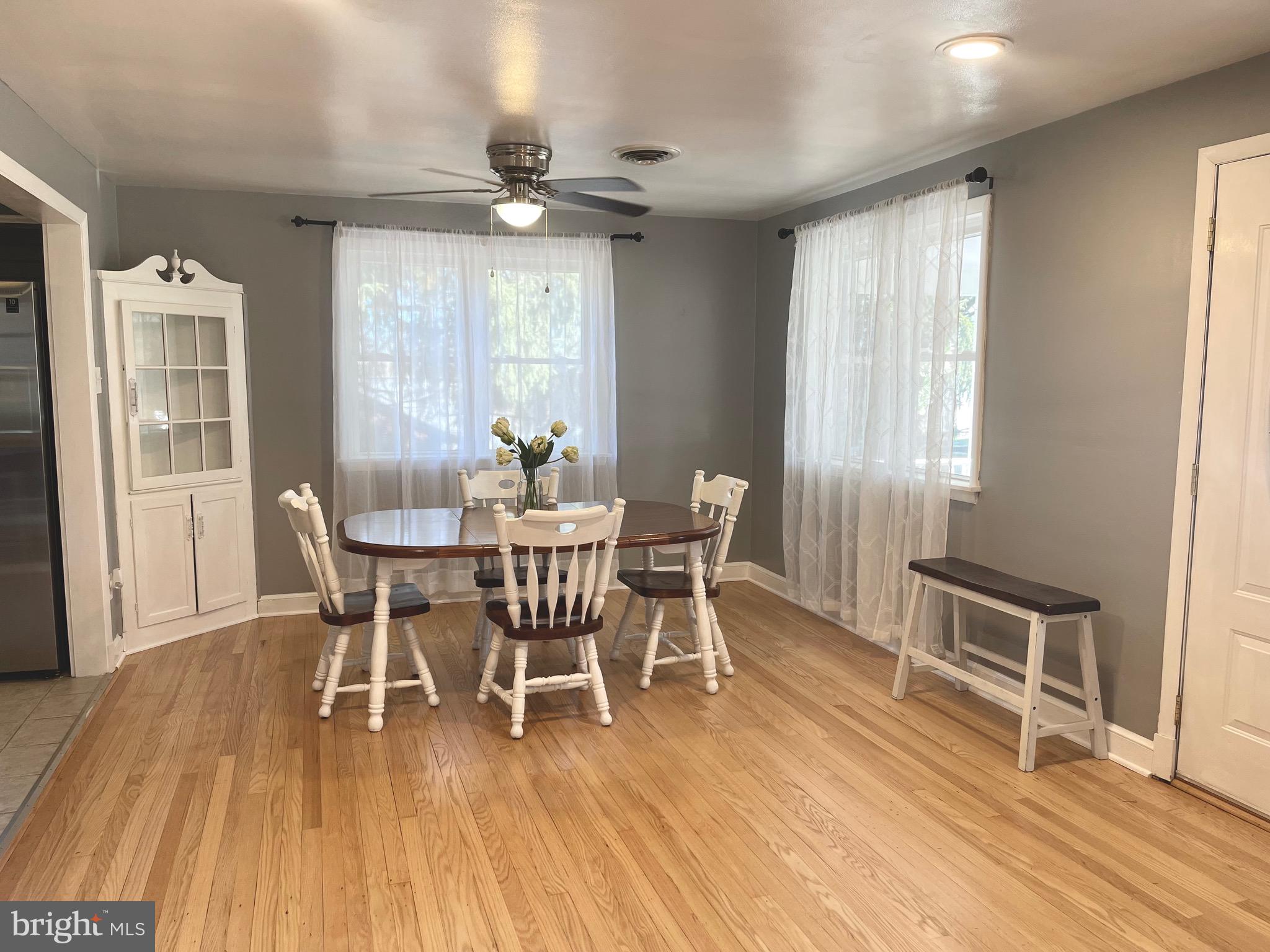 28321 Kemptown Road Damascus, MD 20872 - Photo 6 of 57 a dining room with wooden floor a chandelier a glass table and chairs