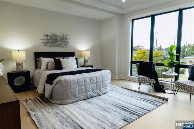 a bedroom with a bed a couch and a large window