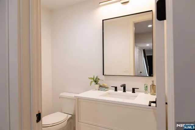 a bathroom with a sink vanity mirror and toilet