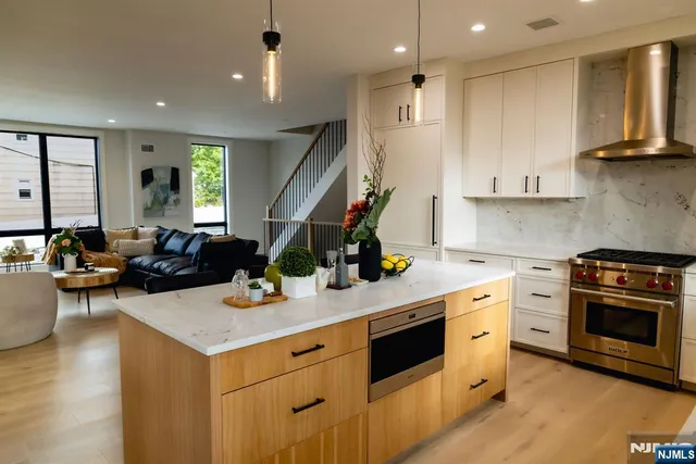 a kitchen that has a lot of cabinets in it and wooden floors