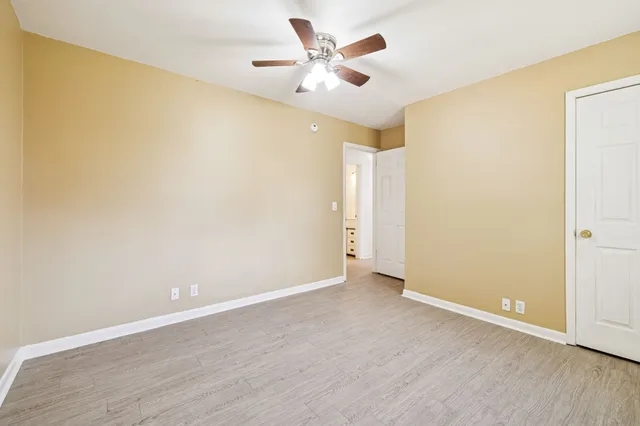 an empty room with a window and a ceiling fan