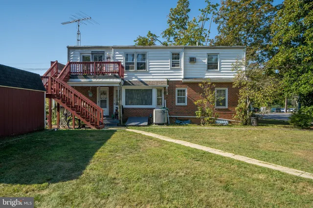 a front view of house with yard and trees in the background