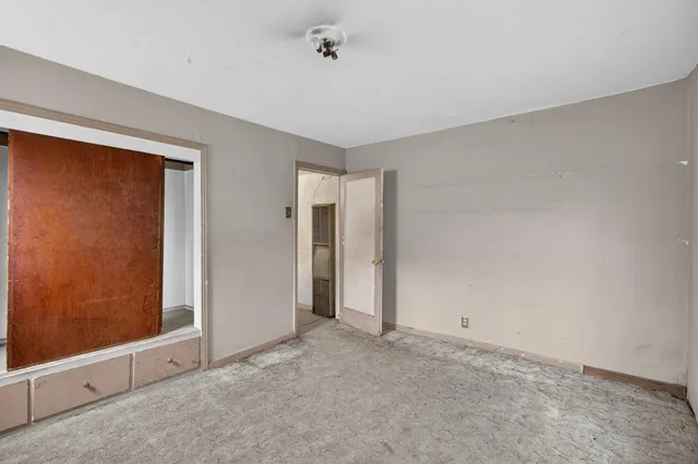 an empty room with a fireplace and a window