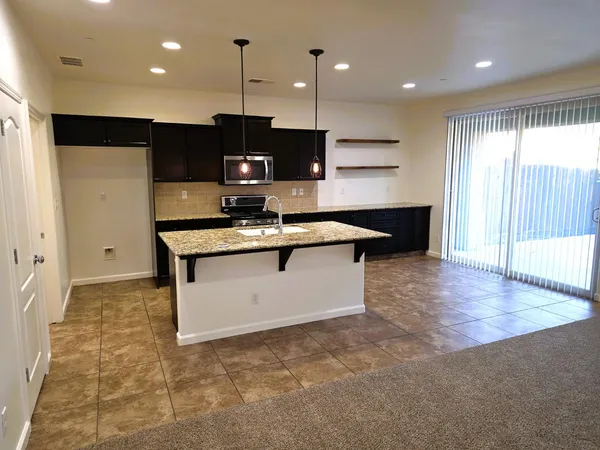 a kitchen with stainless steel appliances granite countertop a stove a sink and a microwave