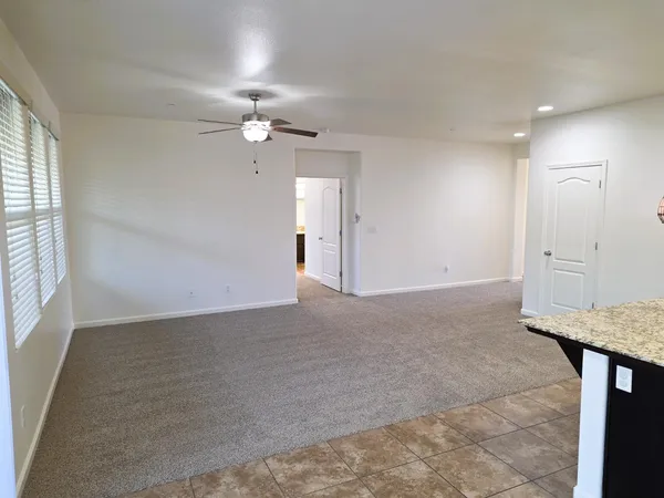 an empty room with fan and windows