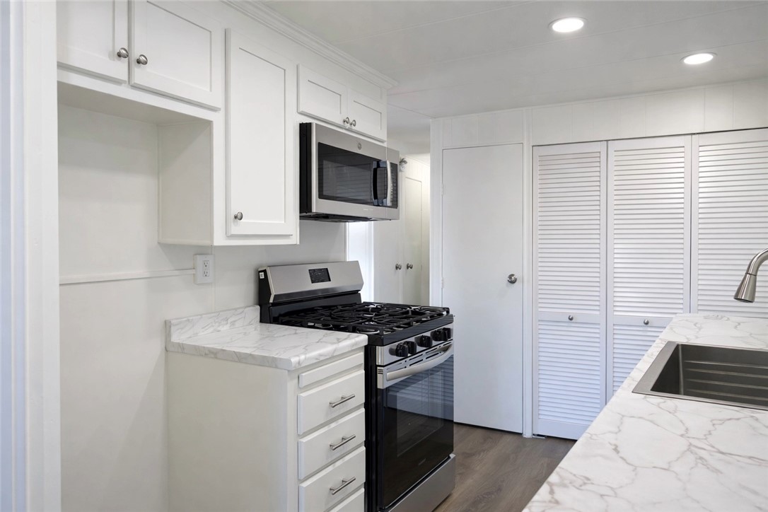 2140 Robin Avenue, Unit 2140A Oxnard, CA 93033 - Photo 6 of 17 a kitchen with white cabinets and stainless steel appliances