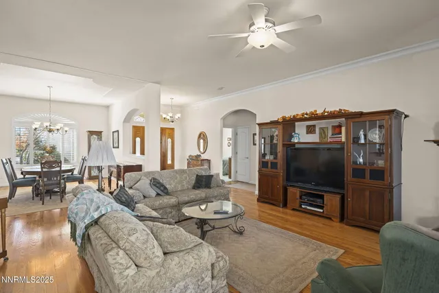 a living room with furniture a flat screen tv and a chandelier