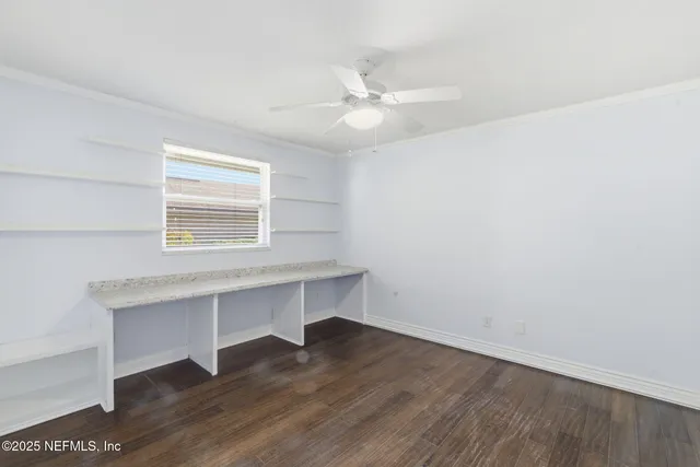 a view of a patio with table and chairs potted plants and floor to ceiling window