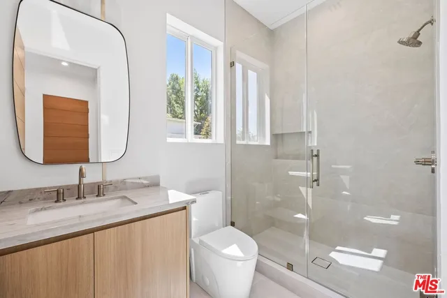 a bathroom with a granite countertop sink toilet and shower