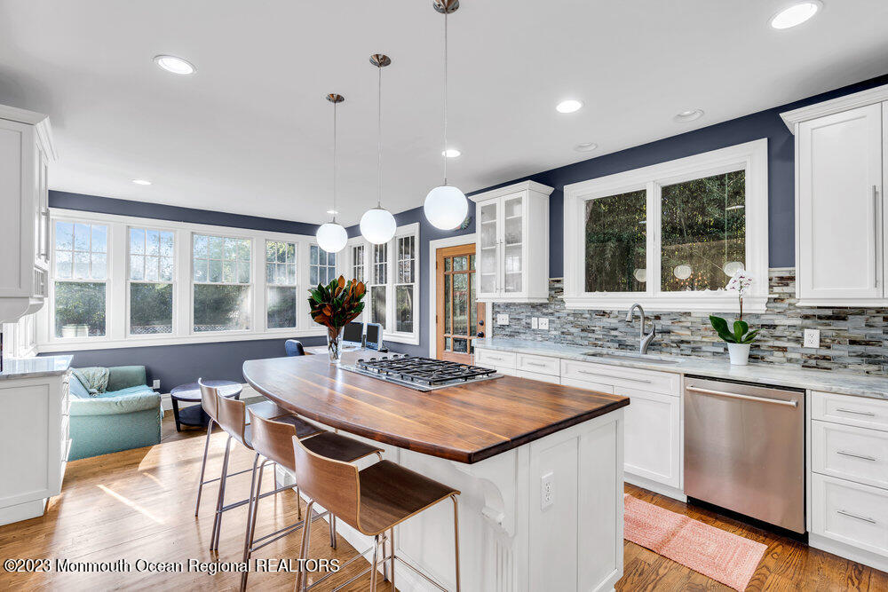 405 Brown Street Brielle, NJ 08730 - Photo 25 of 92 a kitchen with stainless steel appliances granite countertop a stove a sink a microwave a dining table and chairs