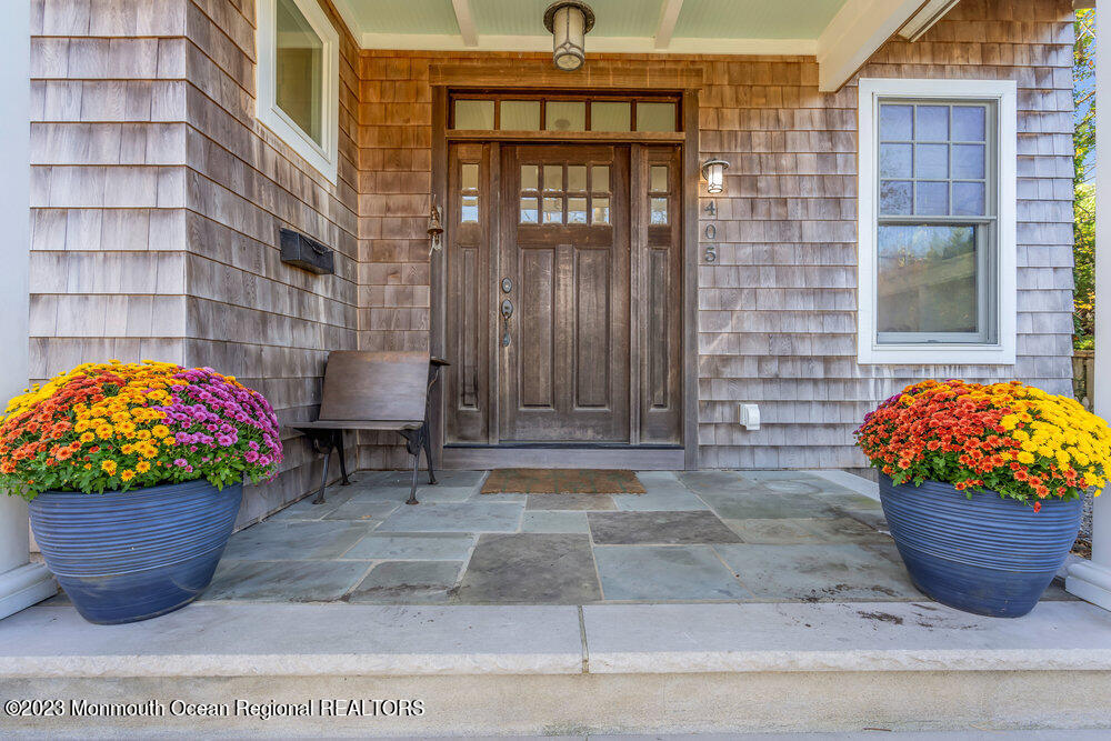 405 Brown Street Brielle, NJ 08730 - Photo 8 of 92 a view of a porch with dining table and chairs and potted plants