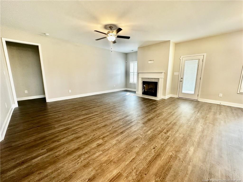 5177 Maxwell Road Stedman, NC 28391 - Photo 3 of 24 an empty room with wooden floor fireplace and windows