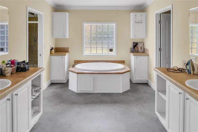 a spacious bathroom with a double vanity sink a mirror and a bathtub