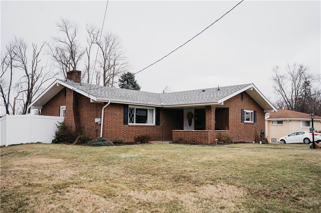 a front view of house with yard and trees