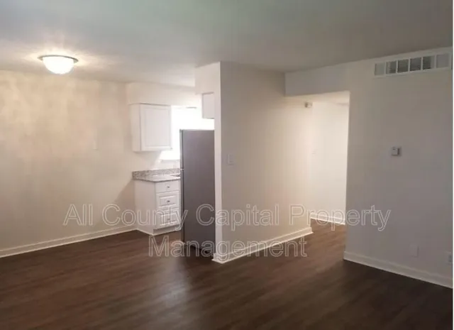 a view of empty room with wooden floor