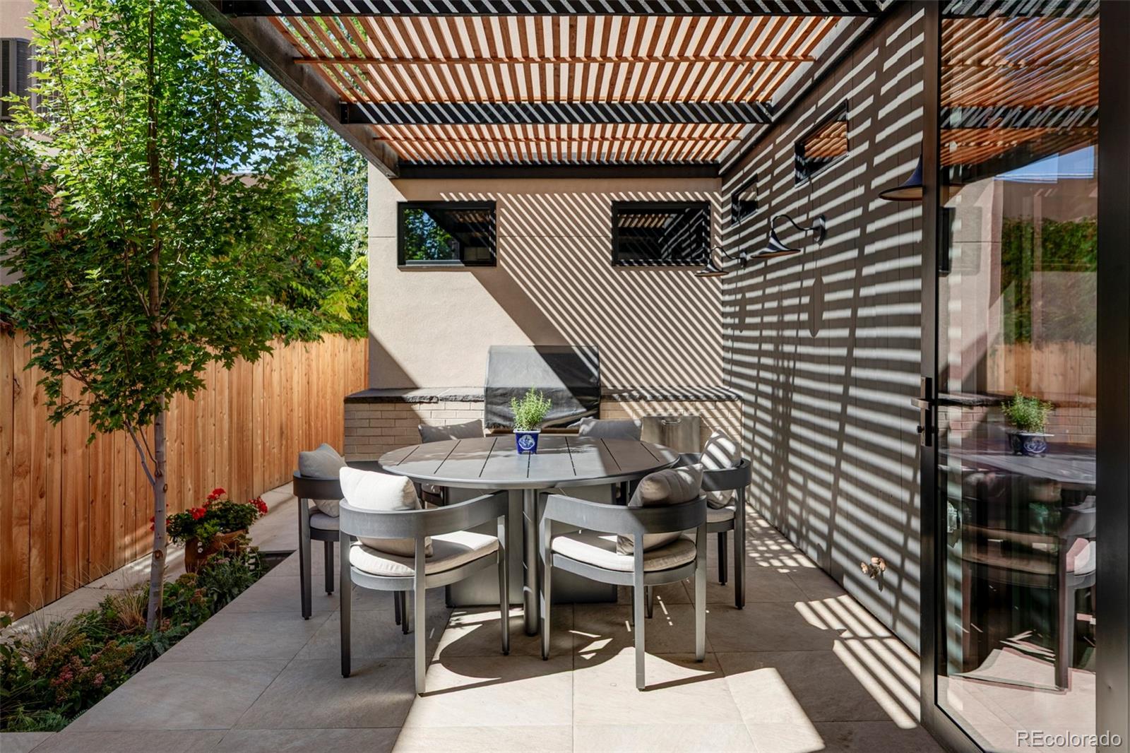255 Jackson Street Denver, CO 80206 - Photo 11 of 32 a view of a patio with table and chairs with wooden floor and fence and a couple of chairs