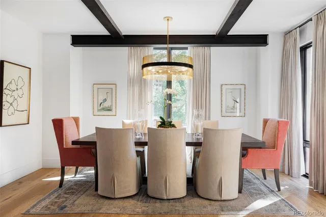 a dining room with furniture a chandelier and wooden floor