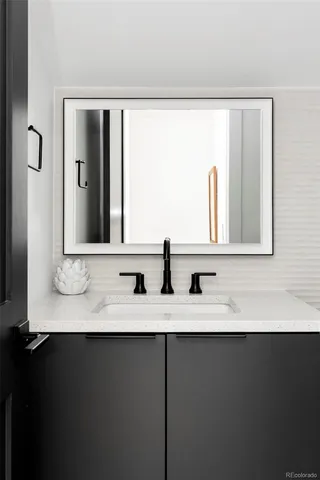 a bathroom with a granite countertop sink and a mirror