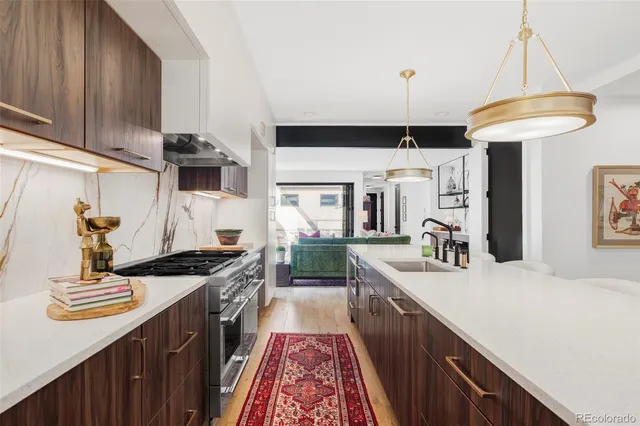 a kitchen with kitchen island granite countertop a sink a counter top space stove and cabinets