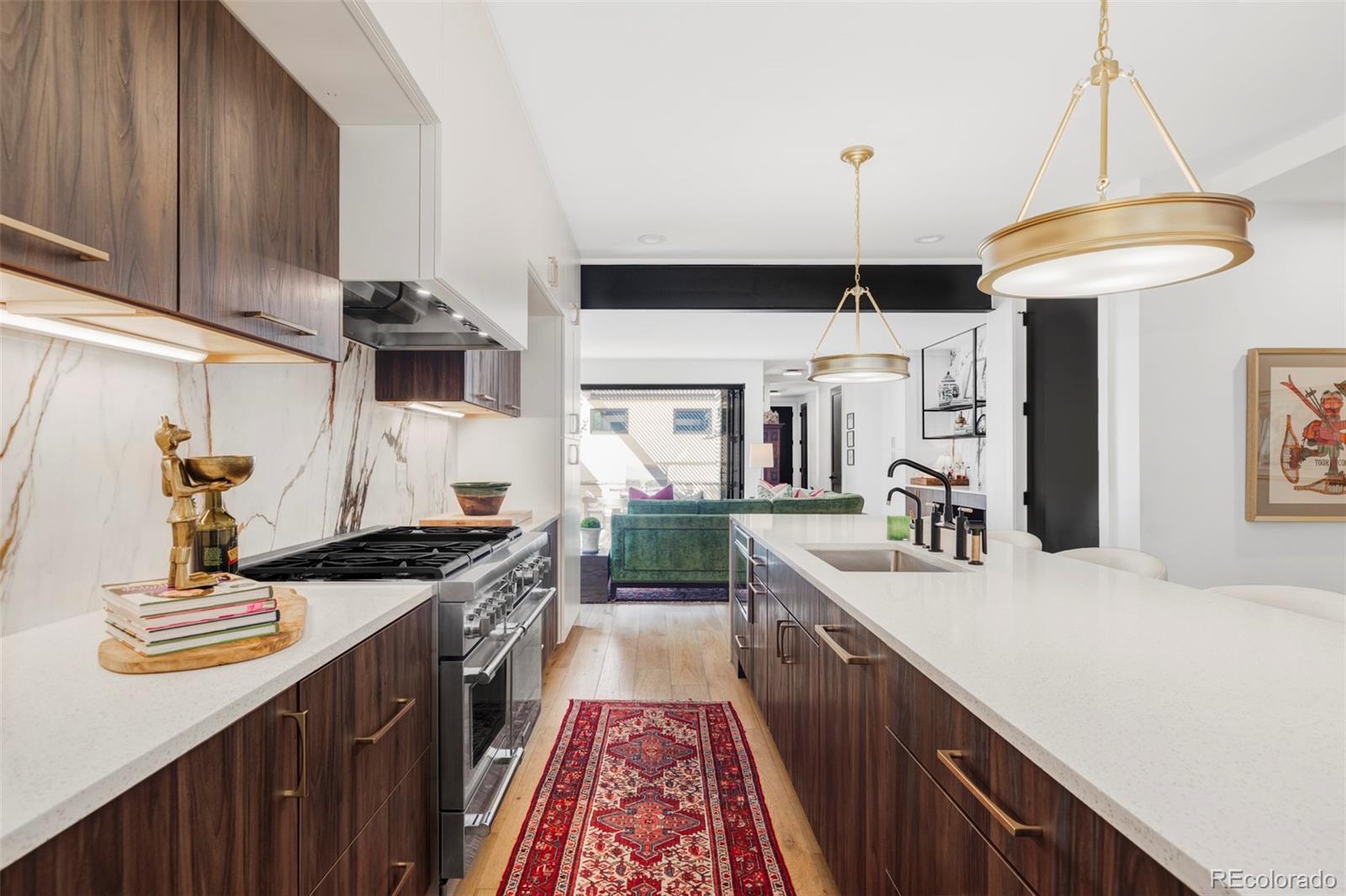 255 Jackson Street Denver, CO 80206 - Photo 6 of 32 a kitchen with kitchen island granite countertop a sink a counter top space stove and cabinets