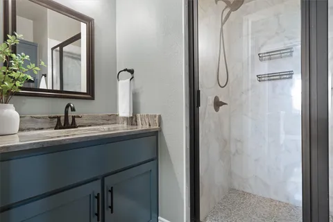 a bathroom with a granite countertop sink and mirror