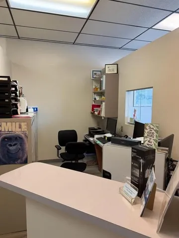 a bedroom with a bed and a computer on a desk next to a window