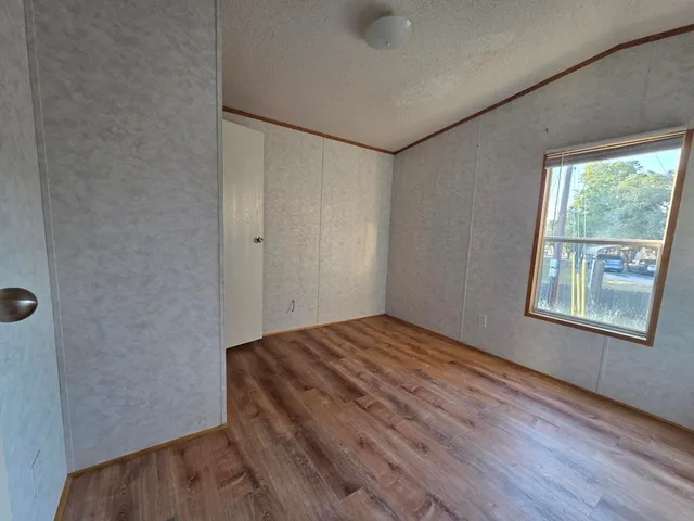 a view of a room with wooden floor and windows