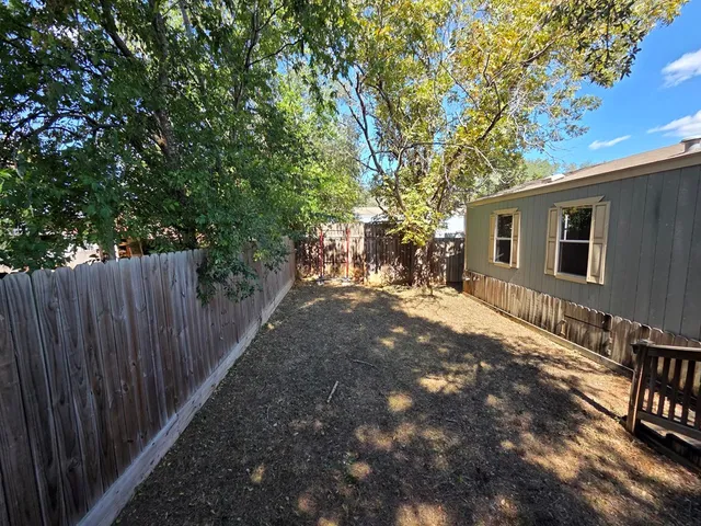a backyard of a house with table and chairs