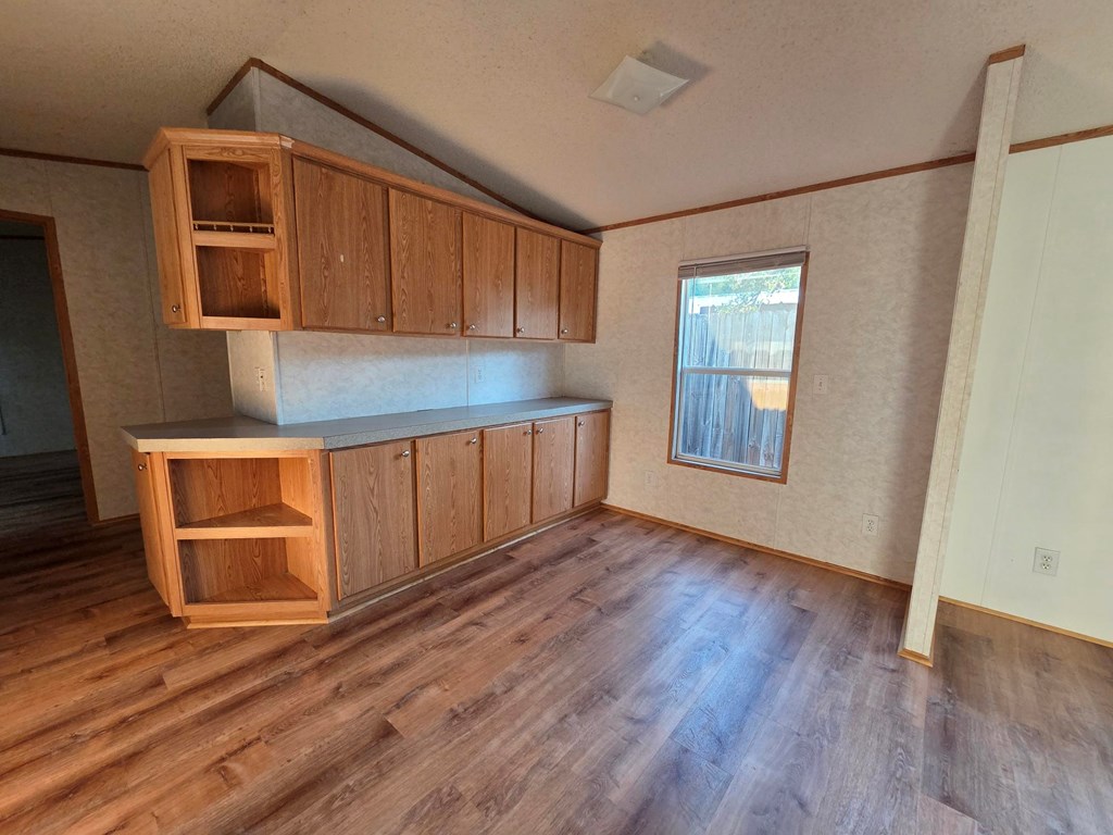 167-2 Beaumont Street Bandera, TX 78003 - Photo 8 of 17 an empty room with wooden floor cabinet and windows