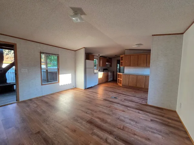 a view of empty room with a window and wooden floor