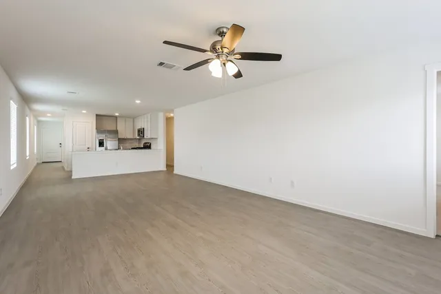 a view of empty room with wooden floor