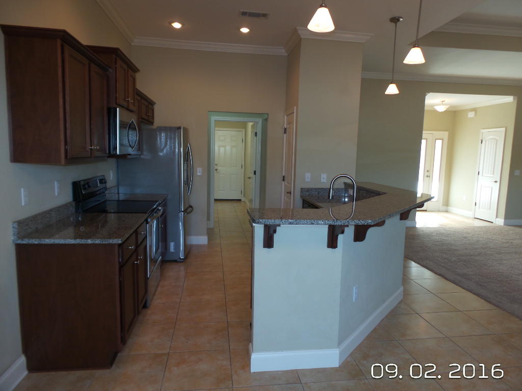 4589 Hermosa Road Crestview, FL 32539 - Photo 8 of 21 a kitchen with stainless steel appliances granite countertop a sink and a refrigerator
