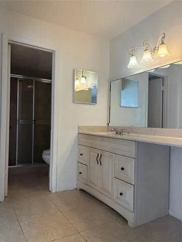a spacious bathroom with a granite countertop sink and a mirror