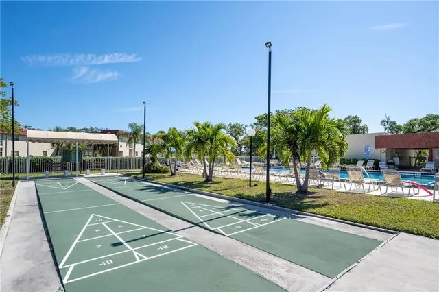 a view of a swimming pool with a yard and palm trees