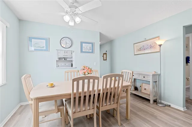 a view of a dining room with furniture and a chandelier fan