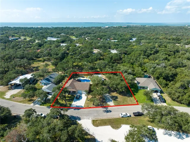 an aerial view of residential houses with outdoor space and trees