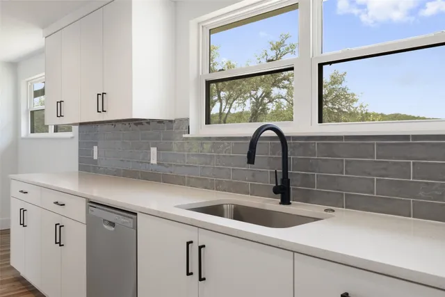 a close view of a sink a faucet and a window in a kitchen